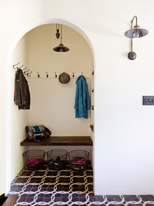 A pulley pendant punches up the rustic allure in this Mediterranean style mudroom. Photo credit: Mediterranean Entry by Portland Interior Designers & Decorators Jessica Helgerson Interior Design