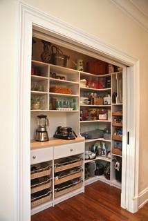 Closet with lots of built-in shelves and drawers.