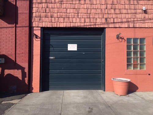 Black commercial garage door in need of upgrade.