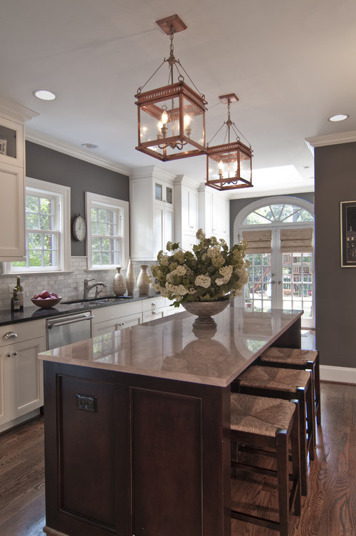 Housekaboodle -Kitchen by Carolina Design Associates has popular color on the walls. Island counter is Calcutta gold marble. Lantern shape gives a nod to the windows