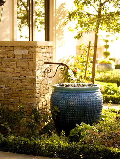 Fountain flowing into a rain barrel