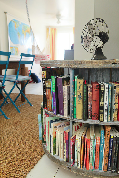 reading room with wire reel book holder with old fan and blue chairs and map