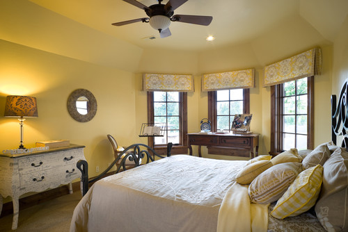 Yellow bedroom with wood trim and wrought iron bed