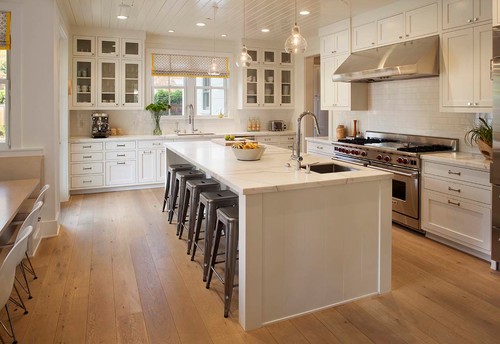A kitchen with an island in the middle of a hard wood floor