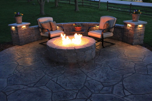 An outdoor patio with a fire pit in the middle.